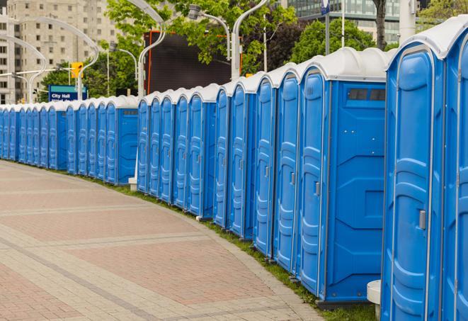 a line of portable restrooms at a sporting event, providing athletes and spectators with clean and accessible facilities in Honeoye Falls